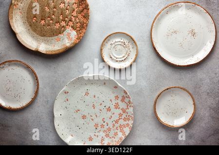 Set of ceramic round bowls and plates on vintage grey background. Flat lay. Stock Photo