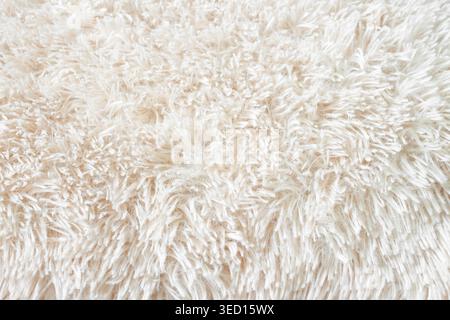 Fluffy long pile soft woolen light beige carpet above view macro Stock Photo