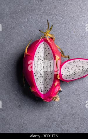 Dragon fruit is sliced open to reveal its white flesh and seeds. Stock Photo