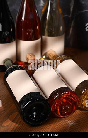 Bottles with plain labels are arranged on a wooden table. Stock Photo