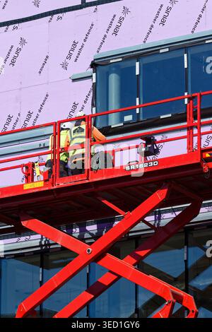Radcliffe civic hall construction site, two construction workers on aerial work platform platform on construction site in greater manchester uk Stock Photo