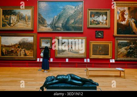 Visitors viewing oil paintings and a marble statue in a Victorian gallery at Leeds Art Gallery, West Yorkshire, England, UK Stock Photo