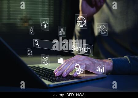 SEO search engine optimization concept. Person typing on laptop with digital search bar and marketing icons to represent web browsing data analysis, Stock Photo