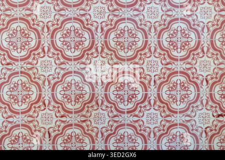 Repeating red and white ceramic tiles with ornate floral and scrollwork motifs. Stock Photo