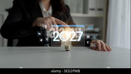 Conceptual image of a business person interacting with futuristic technology and holographic interface featuring bright light bulb for innovative Stock Photo