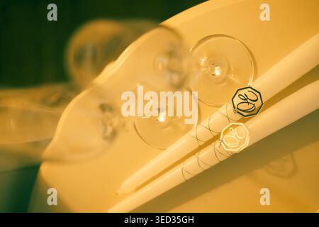 Elegant white heels prepared for  wedding celebration. White high heels sit beside two champagne glasses, small gift box, and decorative item. setting Stock Photo