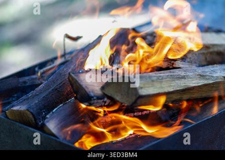Bright orange fire flames in a charcoal grill. Energetic heat and energy background for summer barbecue and kidult design. Stock Photo