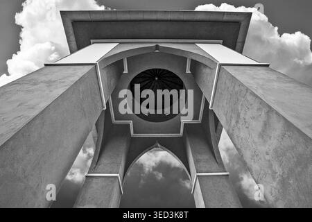 Upward looking view of the Folly memorial structure at Larmer Tree Gardens, Dorset, UK, framed by clouds and stark symmetry in black and white. Stock Photo