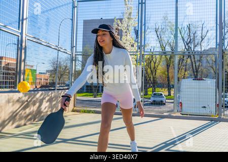 Young woman playing pickleball in an outdoor court Stock Photo