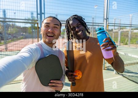 Diverse friends taking selfie celebrating pickleball game Stock Photo