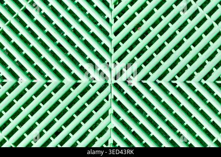 Green plastic flooring creating a vibrant abstract pattern with diagonal lines Stock Photo