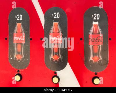 Detail of a red Coca-Cola vending machine in Mexico, showing drink-selection buttons priced at 20 pesos Stock Photo