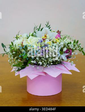 Flower bouquet arrangement in a round box on a wooden table Stock Photo
