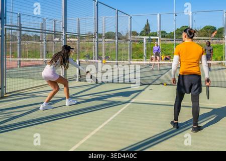 Diverse friends enjoying active pickleball game on court Stock Photo