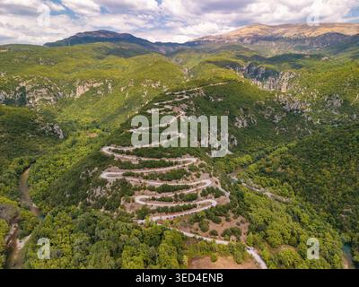 Aerial view of a winding road and a river flowing through a deep ...