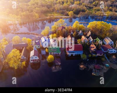 Flooded small village after river overflow. Concept of natural disaster, aerial drone view. Stock Photo