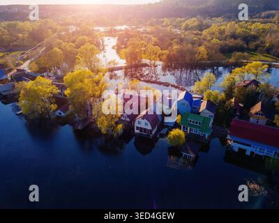Flooded small village after river overflow. Concept of natural disaster, aerial drone view. Stock Photo