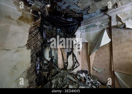 Damaged wall aftermath of explosion and fire after attack. Stock Photo