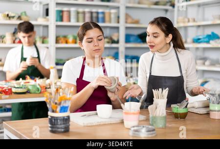 Two young women making pottery in workshop Stock Photo