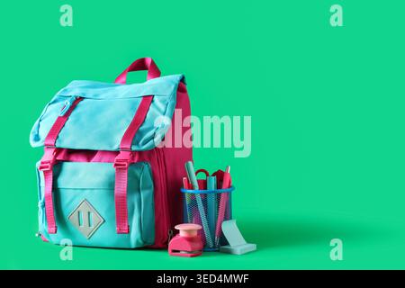 Stylish school backpack and different stationery on green background Stock Photo