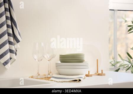 Clean dishes and glasses on counter in kitchen Stock Photo