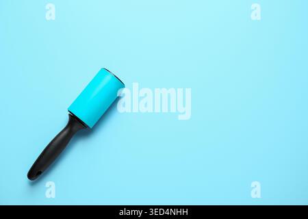 Lint roller on blue background Stock Photo