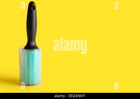 Lint roller on yellow background Stock Photo