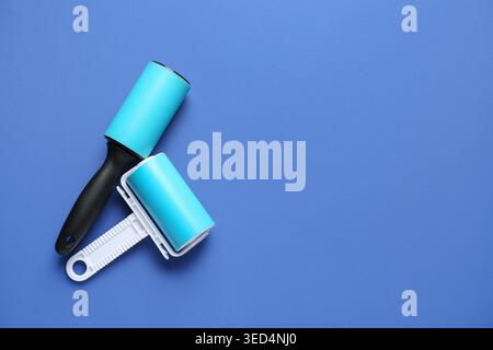 Different lint rollers on blue background Stock Photo