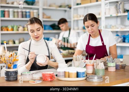 Two young women making pottery in workshop Stock Photo
