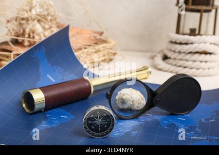 Composition with modern compass, world map, spyglass and magnifier on white background Stock Photo