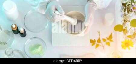 Scientist with mortar and natural ingredients in laboratory, top view Stock Photo