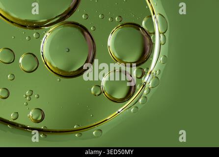 Overlapping oil spheres on a vivid green background suggesting organic cell structures Stock Photo