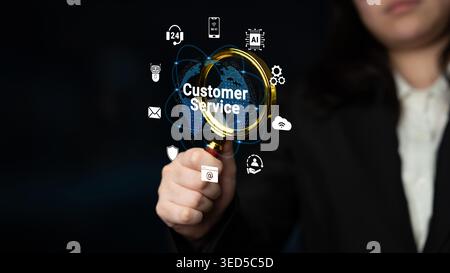 A business professional uses a magnifying glass to highlight customer service with digital icons. This image symbolizes focus on client needs and Stock Photo