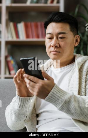 Man Using Smartphone on Couch Stock Photo