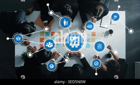 A group of professionals engages in collaborative management strategies around a conference table, analyzing data and planning for future goals in a Stock Photo