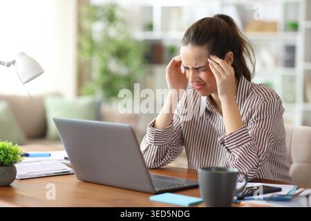 Self employed suffering hard migraine working at home Stock Photo