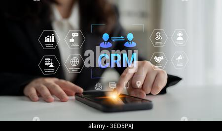 A business professional interacts with a smartphone displaying customer relationship management visuals, highlighting digital solutions for effective Stock Photo