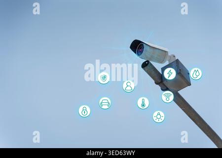 Outdoor CCTV camera with digital security and IoT icons on blue sky background, ideal for smart surveillance, safety systems, automation, monitoring, Stock Photo