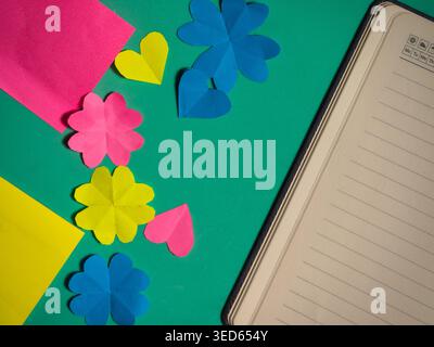 Colorful sticky notepads and diary on green background Stock Photo
