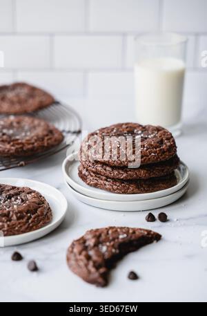Plates of chocolate brownie cookies and milk on white background. Stock Photo