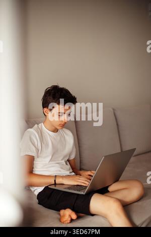 Concentrated teenager working on computer from home Stock Photo