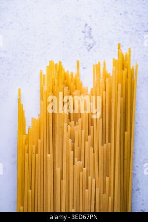 Close up of dry uncooked spaghetti noodles on stone counter. Stock Photo