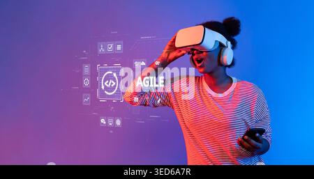 A young woman fully immersed in virtual reality with a headset, expressing excitement, while a digital interface glows in the backdrop, showcasing a Stock Photo