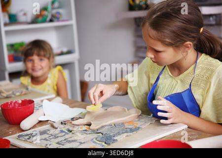 Kids molded from clay at pottery class. Stock Photo