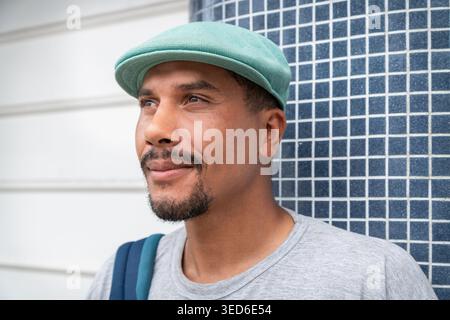 portrait of a young Latin Hispanic man in casual clothing looking confidently into the distance while standing in a modern city setting Stock Photo