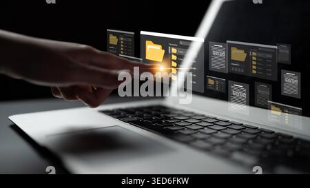A close-up view of a hand interacting with a digital interface on a laptop screen, showcasing folders and files in a modern workspace, highlighting Stock Photo