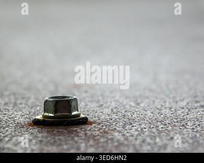 Macro close-up of hexagonal nut on weathered rusty metal surface, industrial hardware detail Stock Photo