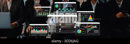 A business team engaged in data analysis with digital screens displaying colorful graphs and charts, reflecting statistics and trends in a sleek Stock Photo