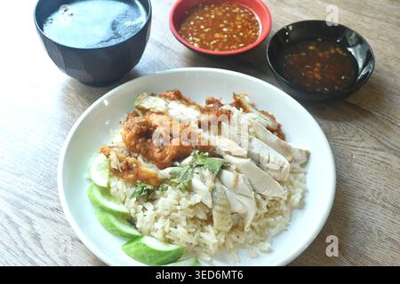 steamed rice topping chop crispy fried and boiled chicken on plate with chili sauce couple soup Stock Photo