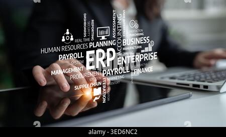 A business professional interacts with a laptop displaying a vibrant digital concept of ERP, highlighting key aspects of enterprise resource planning Stock Photo